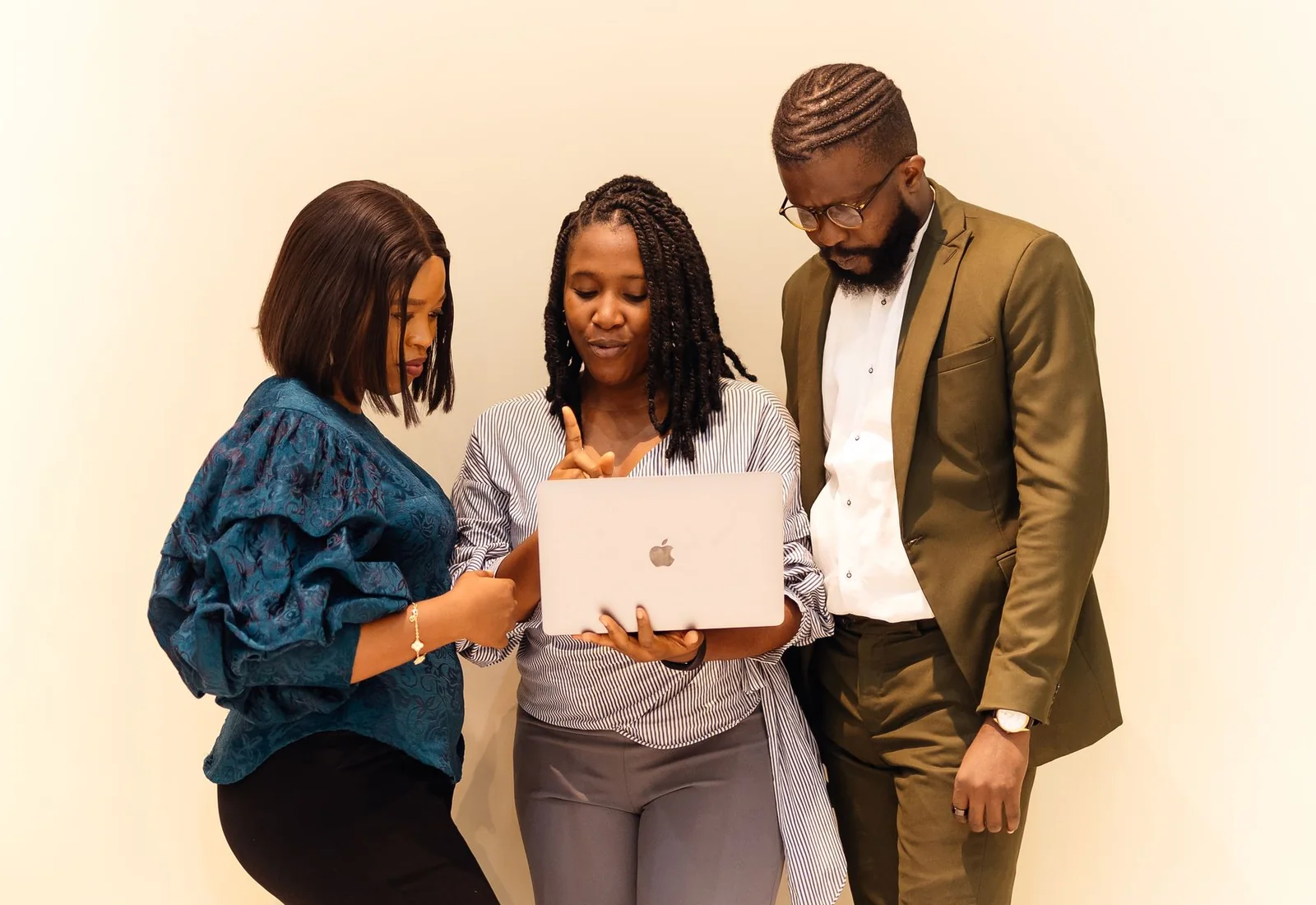 Three business professionals reviewing shared information on a laptop